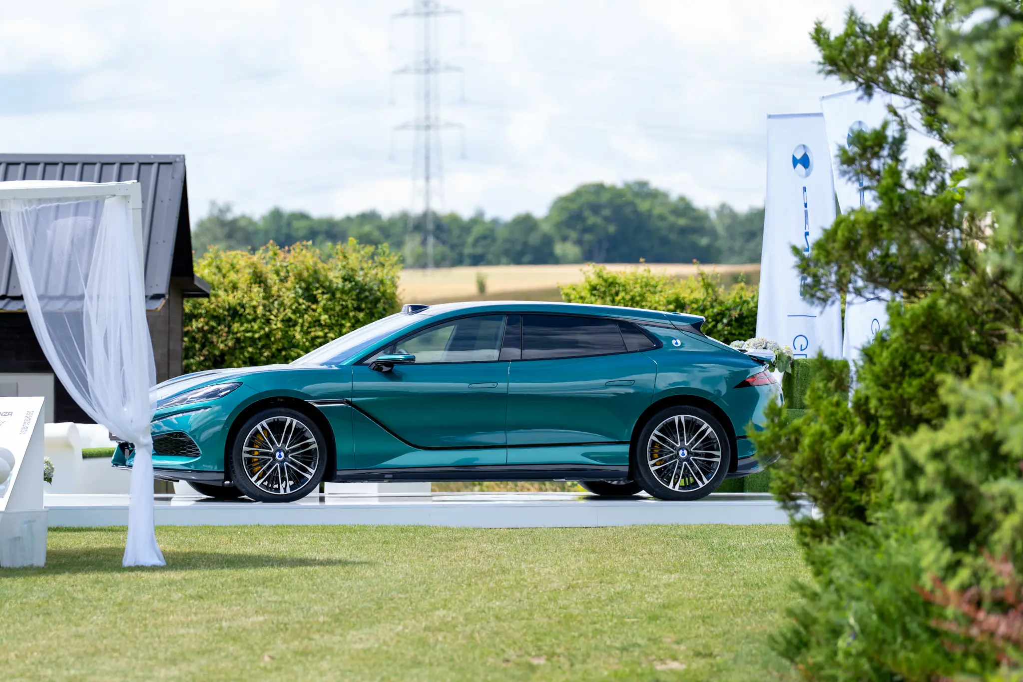 DENZA Z9 GT w kolorze morskim na białym podeście, pole golfowe w Tokarach