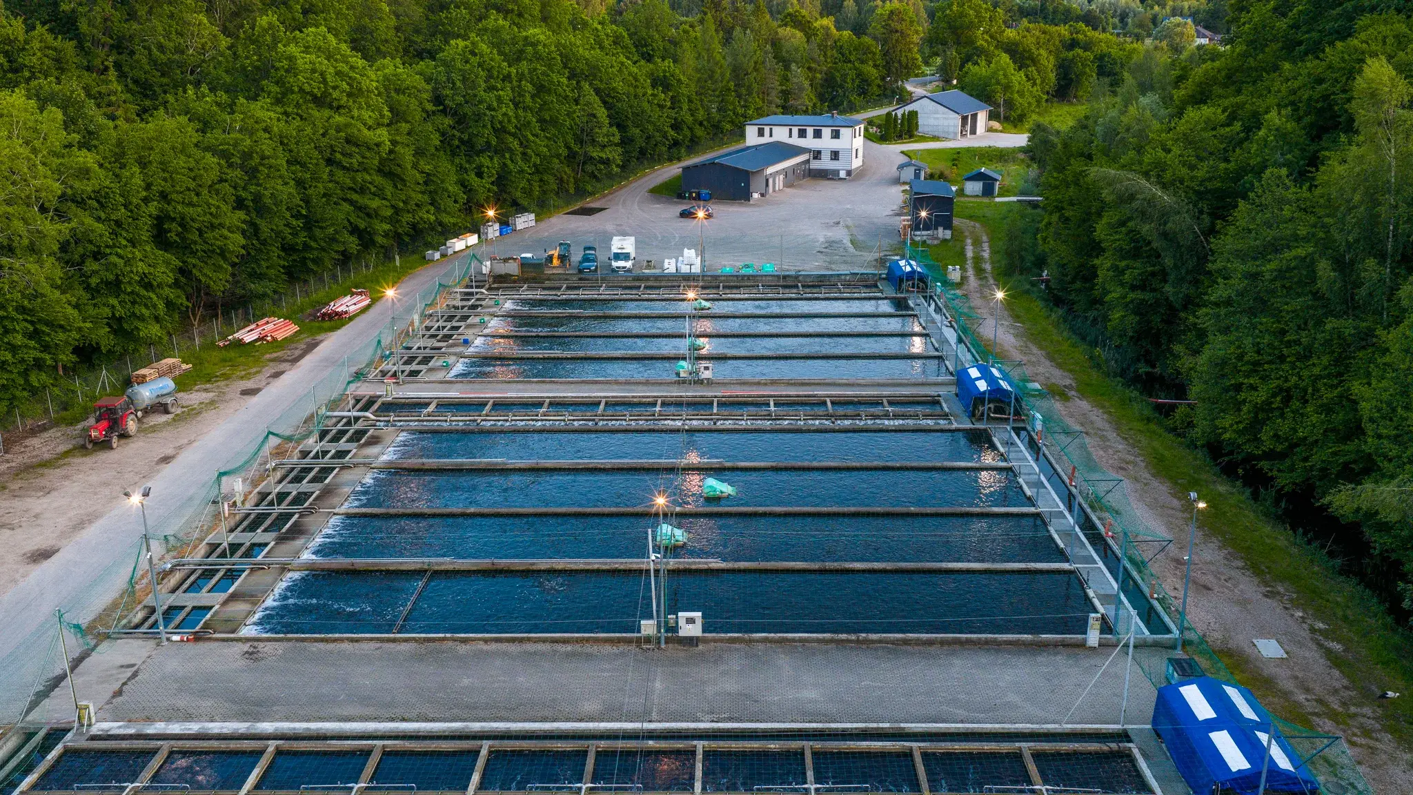 Hodowla pstrąga K2 z lotu ptaka – baseny hodowlane wśród lasów, zdjęcie z drona